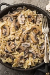 Farfalle aux champignons à la crème et au vin blanc, un plat savoureux.