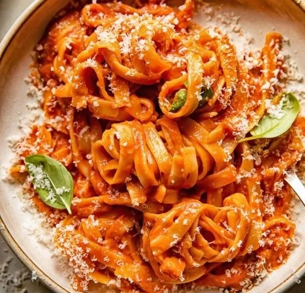 Tagliatelles à la pancetta avec basilic et mozzarella délicieusement garnies.